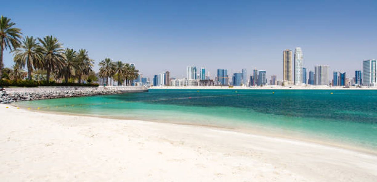Dubai, UAE  april 19, 2022: Al Mamzar Beach Park, high-rise buildings in the area Al Khan Sharjah, palm trees